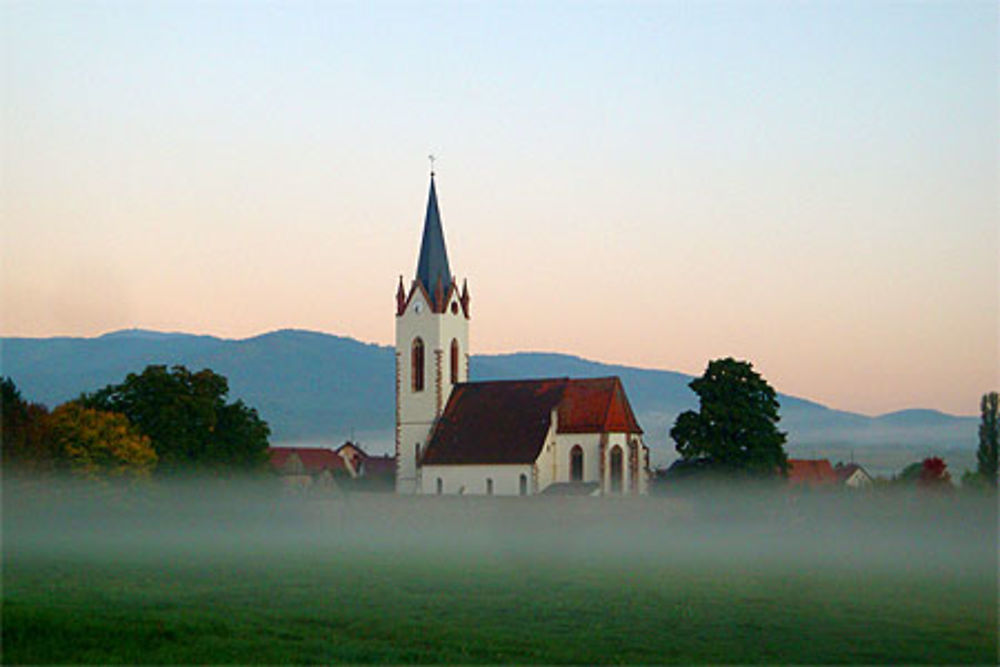 Lever de soleil sur l'église et son cimetière fortifié