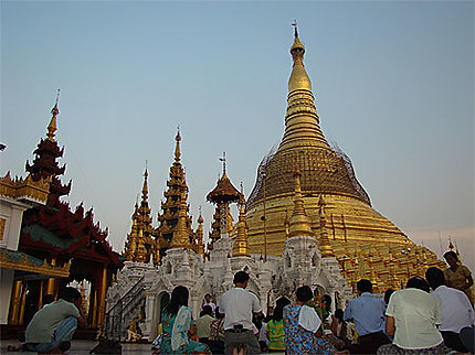 Pélerins priant au pied du stupa de Shwedagon au coucher de soleil