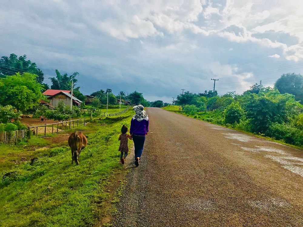 Promenade d'une mère, sa fille et une vache