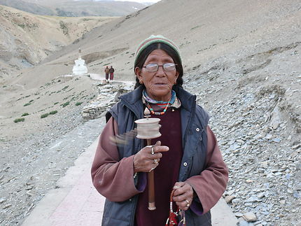 Une tibétaine tournant le moulin à prières