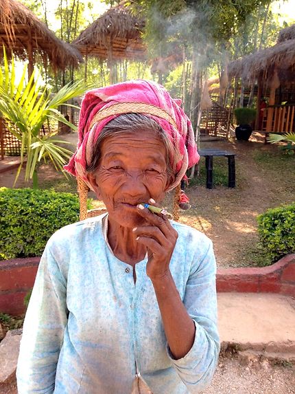 Femme birmane fumant son cigare de bambou