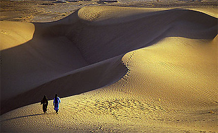 Nomades touaregs marchant dans les dunes