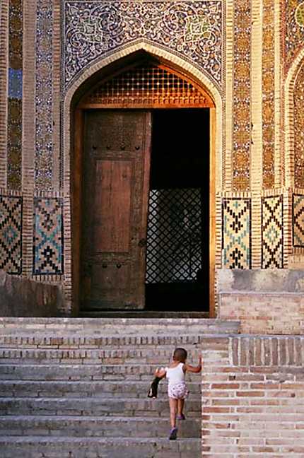 Un enfant joue devant Mir-i-Arab