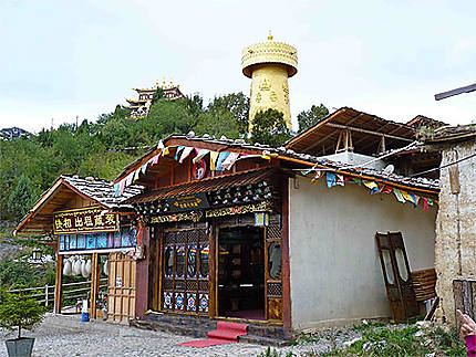 Maisons boutiques et en fond le moulin à prière géant de Zhongdian