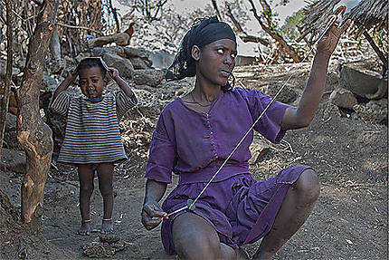 Jeune femme filant la laine