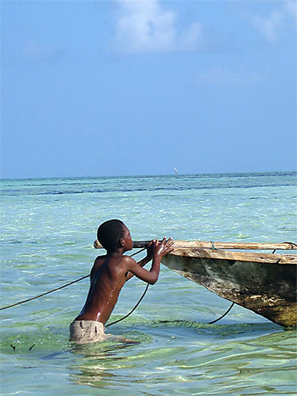 Enfant jouant avec une barque à Nungwi