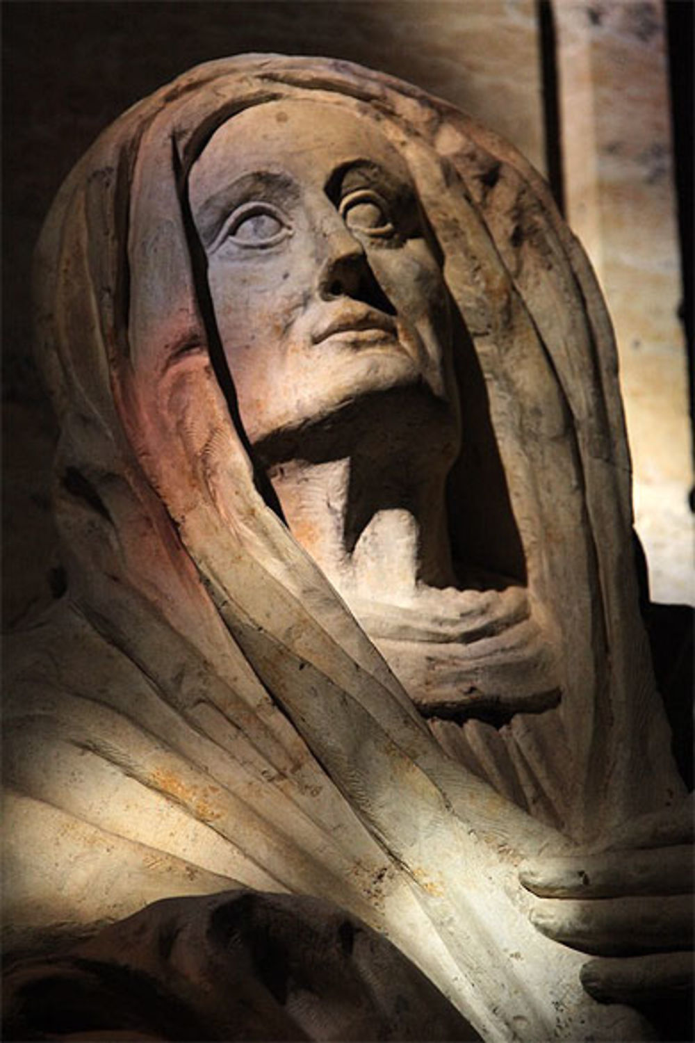 Statue sur un retable en pierre dans un rayon de soleil