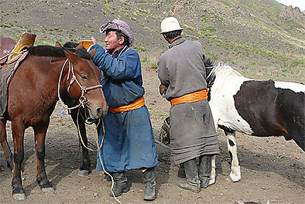 Deux cavaliers préparent leur monture