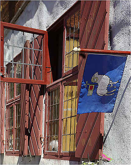 Le drapeau de Gotland sur une façade avec des fenètres